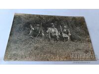 Φωτογραφία Τριών κυνηγών με κυνηγόσκυλο και δύο τροφιαία λαγούς