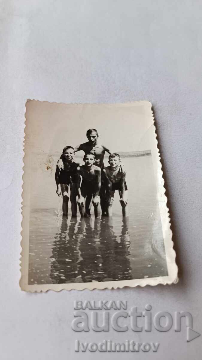 Photo: Young man and three boys on the seashore