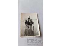 Φωτογραφία Νέος άνδρας και τρία αγόρια στην παραλία