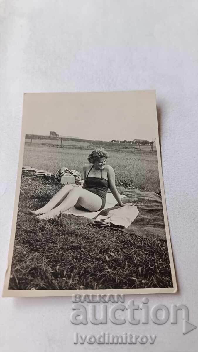 Fotografie Tânăra femeie cu costum de baie retro șezând pe iarbă 1959