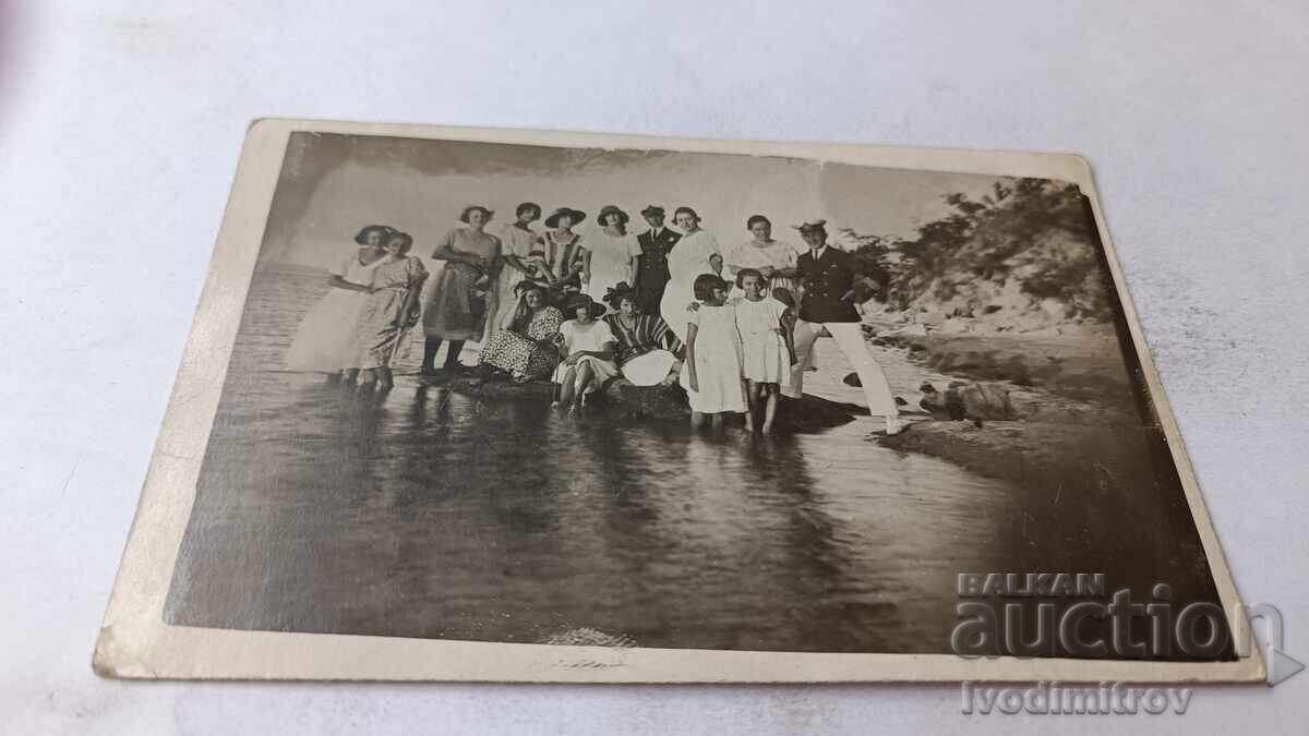 Φωτογραφία Δύο αξιωματικοί και νεαρά κορίτσια σε βράχο στη θάλασσα