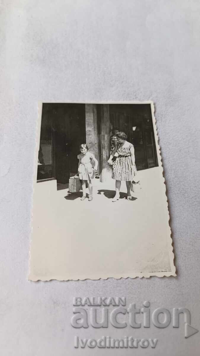 Φωτογραφία Σόφιας, Γυναίκα και κορίτσι με μεγάλη βαλίτσα μπροστά από ΤΑΜΠΣΟ 1962 Φωτογραφία Σόφιας, Γυναίκα και κορίτσι με μεγάλη βαλίτσα μπροστά από ΤΑΜΠΣΟ 1962