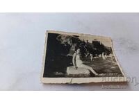 Fotografie cu o tânără fată șezând pe o piatră în râu