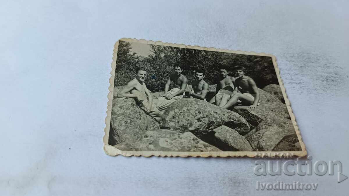 Photo: Young men, shirtless, on large, smooth stones Photo: Young men, shirtless, on large, smooth stones