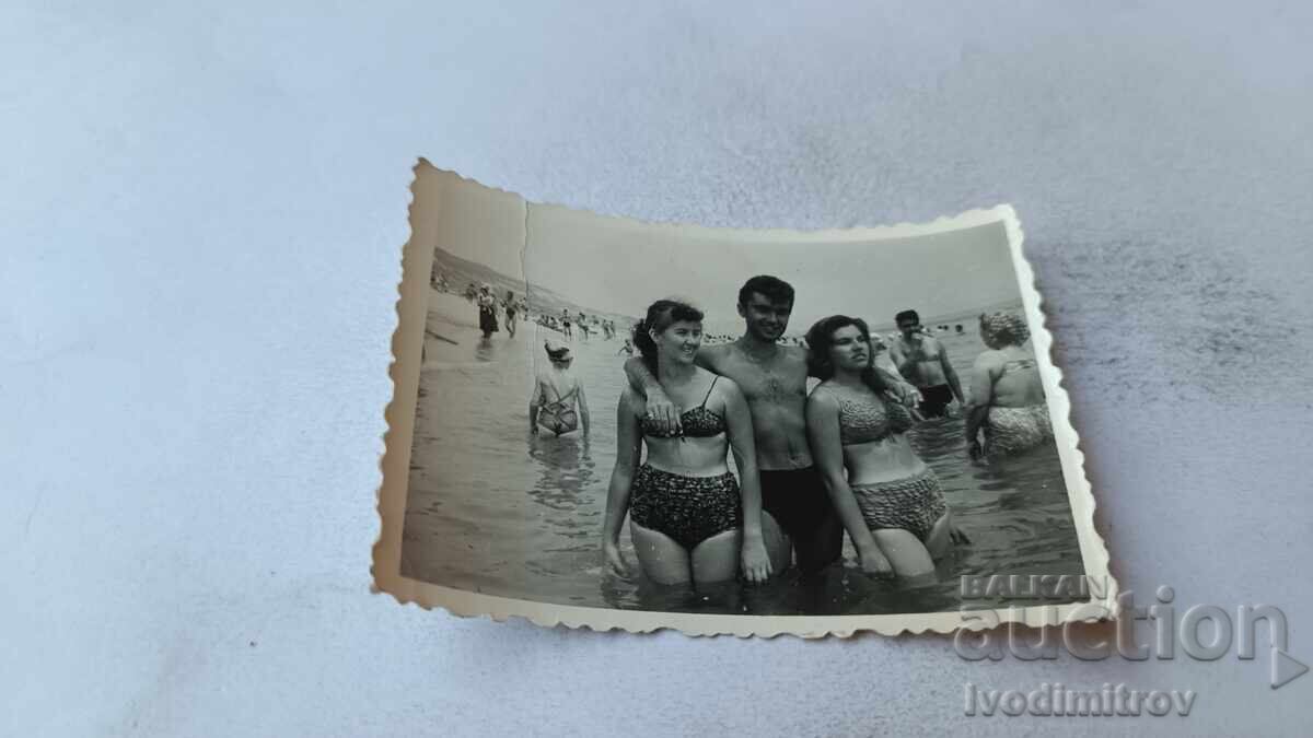 Φωτογραφία Νεαρός άνδρας και δύο νεαρά κορίτσια στην ακτή