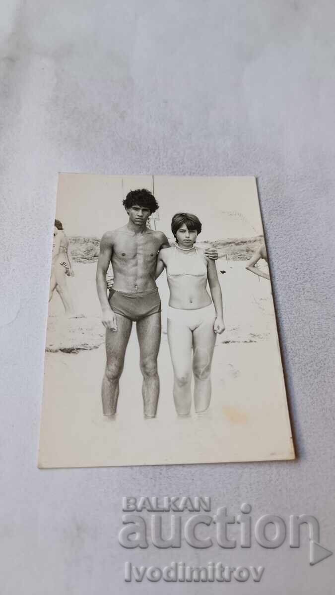 Photo of a Young Man and a Young Girl on the Beach