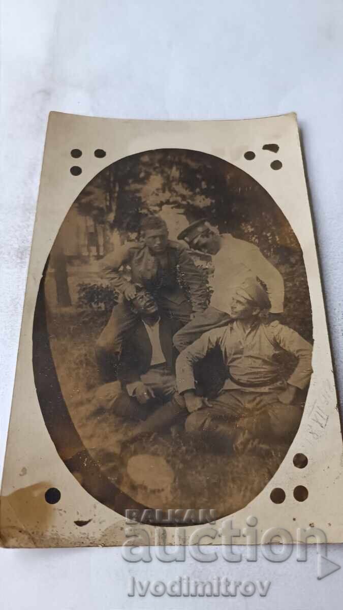 Φωτογραφία Τριών στρατιωτών και γελώντος νεαρού άνδρα