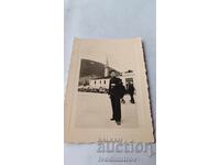 Photo of a Young Person on a Square with Retro Cars