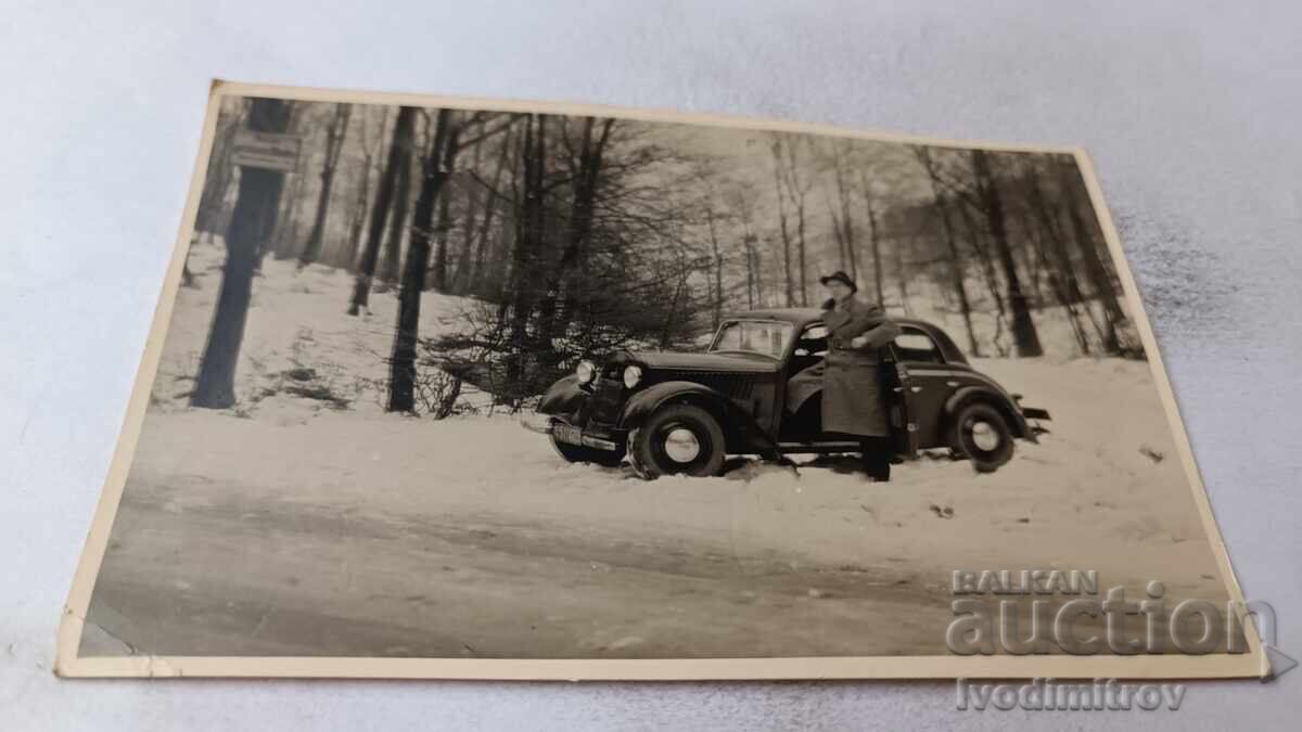 Photo of a man with a retro car in the forest during winter Photo of a man with a retro car in the forest during winter