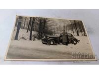 Φωτογραφία Άνδρας με ρετρό αυτοκίνητο στο δάσος το χειμώνα