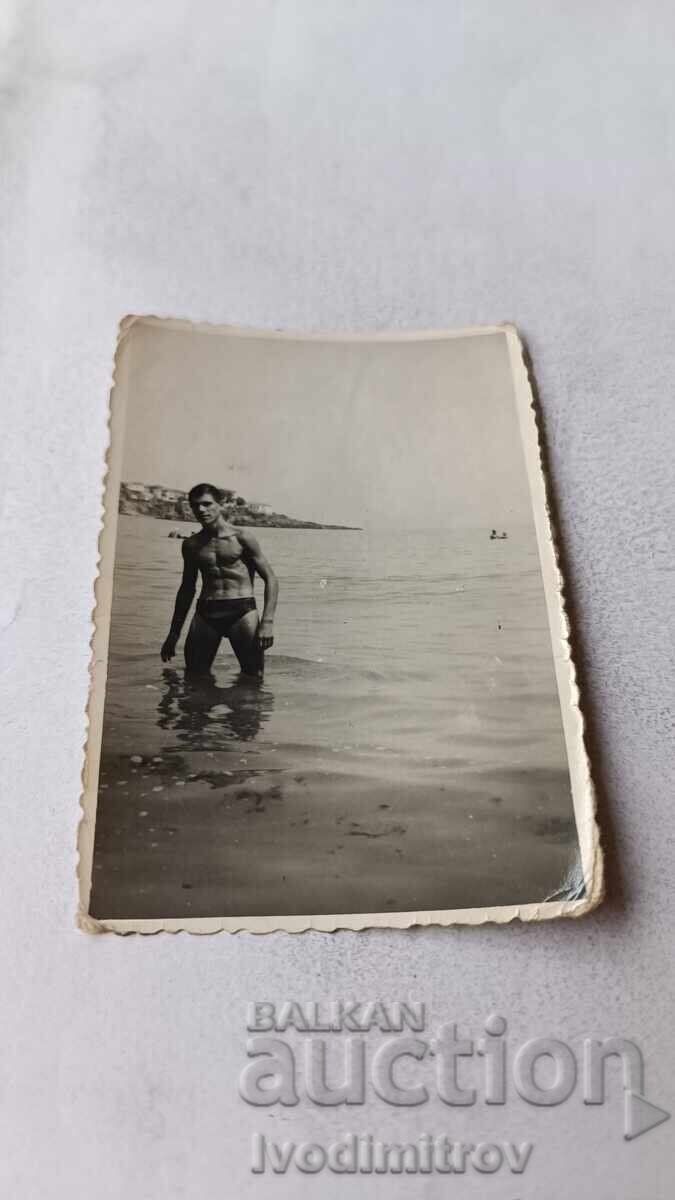 Fotografie Bărbat în costum de baie lângă mare