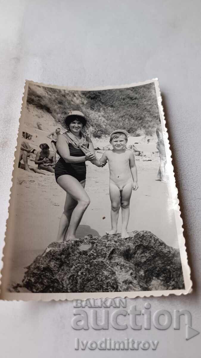 Φωτογραφία Γυναίκας και αγοριού σε βράχο δίπλα στη θάλασσα