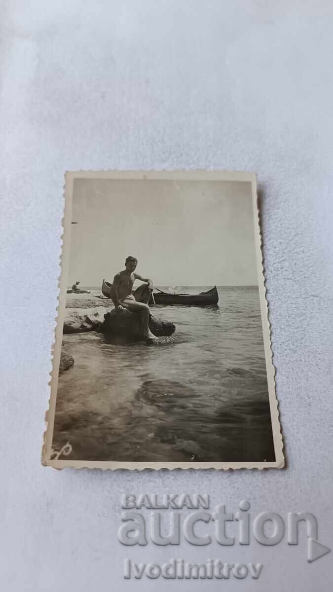 Снимка Варна Млад мъж седнал на камък на брега на морето