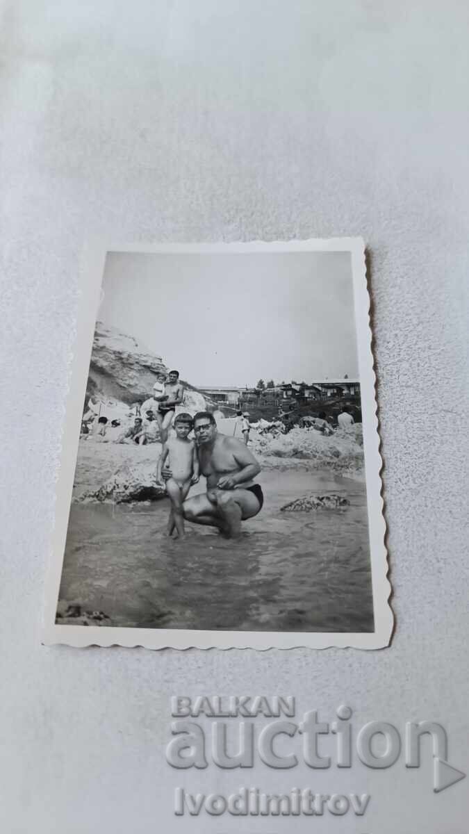 Снимка Мъж и малко момченце на брега на морето