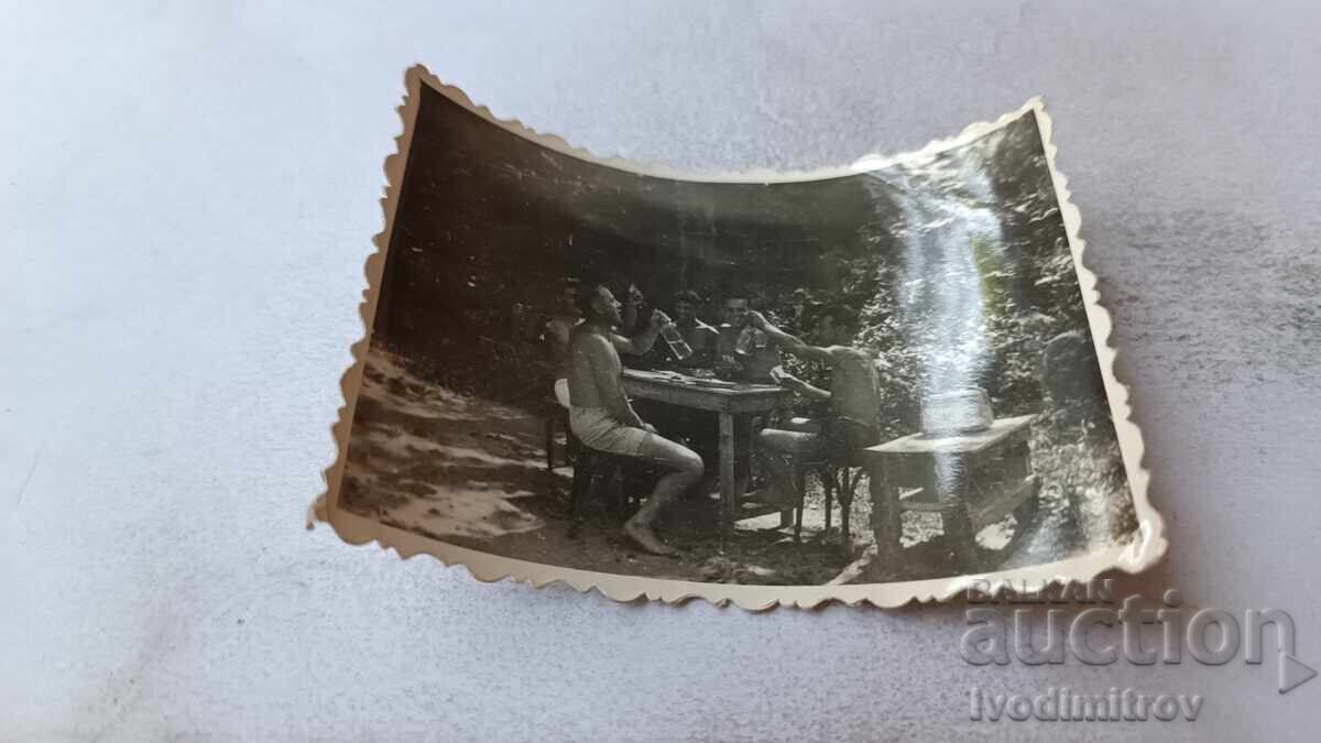 Photo of Young Men in Shorts Having Drinks Photo of Young Men in Shorts Having Drinks