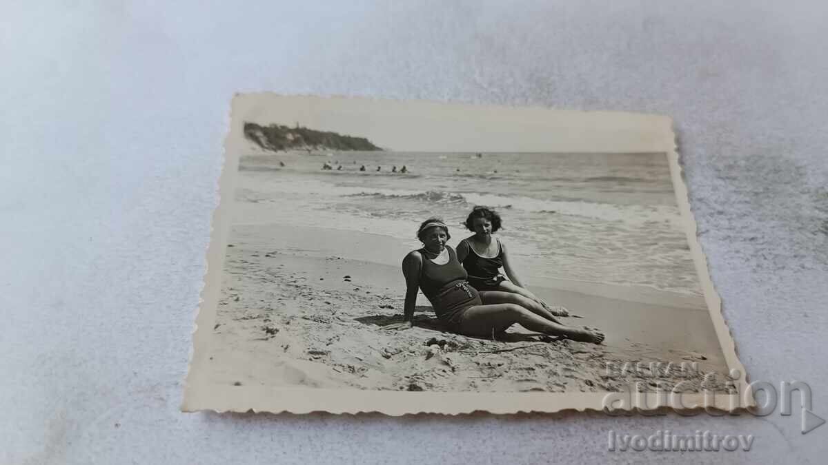 Fotografie Femeie Vrăjitoare și fată tânără stând pe malul mării Fotografie Femeie Vrăjitoare și fată tânără stând pe malul mării