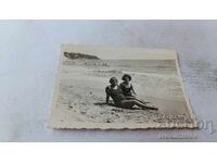 Fotografie Femeie Vrăjitoare și fată tânără stând pe malul mării