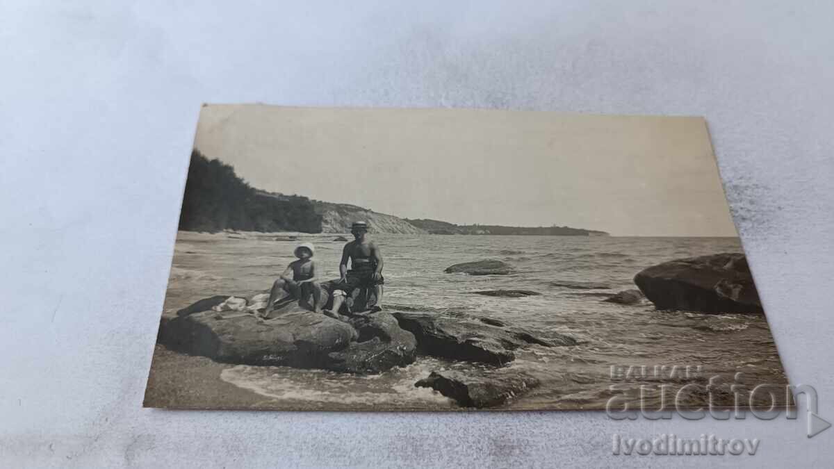 Φωτογραφία Βάρνα Άνδρας και αγοράκι καθισμένοι σε βράχο δίπλα στη θάλασσα 1923