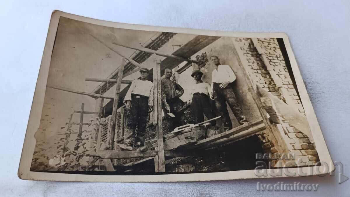 Photo of Four Men on Scaffolding at a Newly Built House