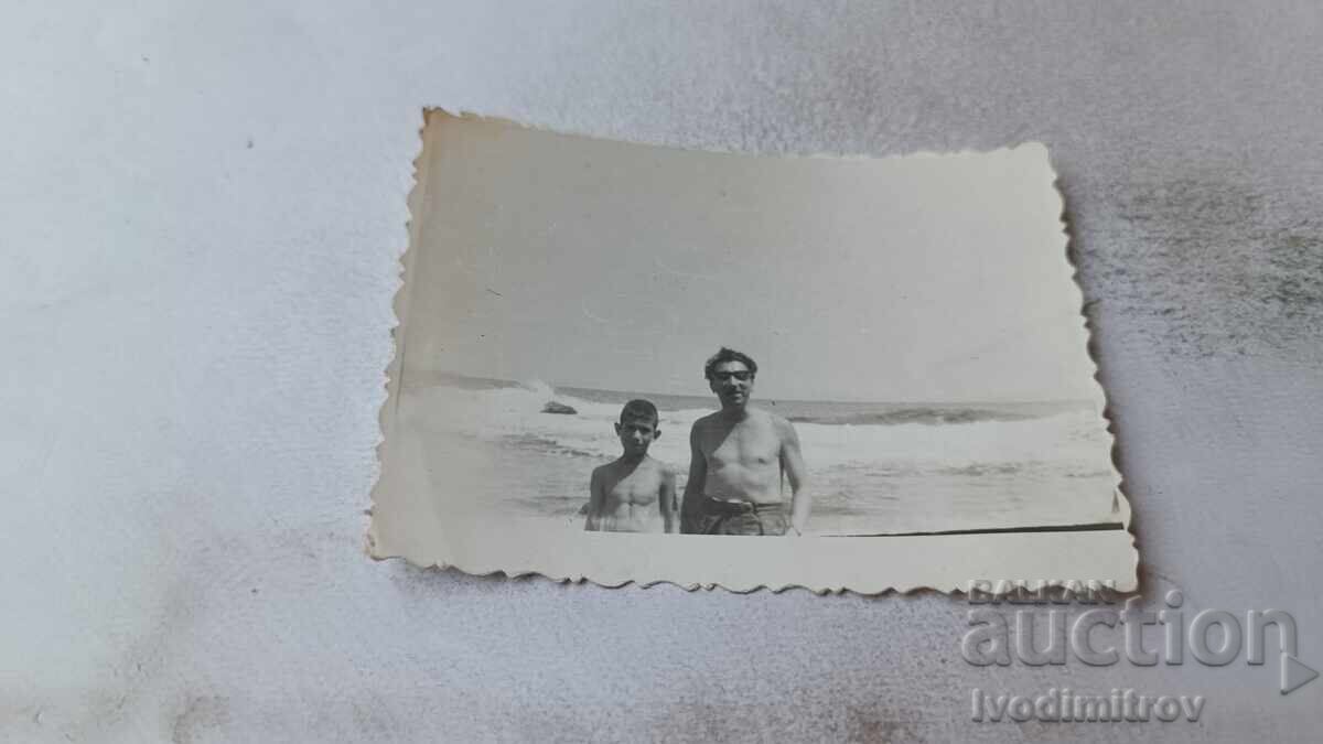 Снимка Мъж и момче на брега на морето Снимка Мъж и момче на брега на морето