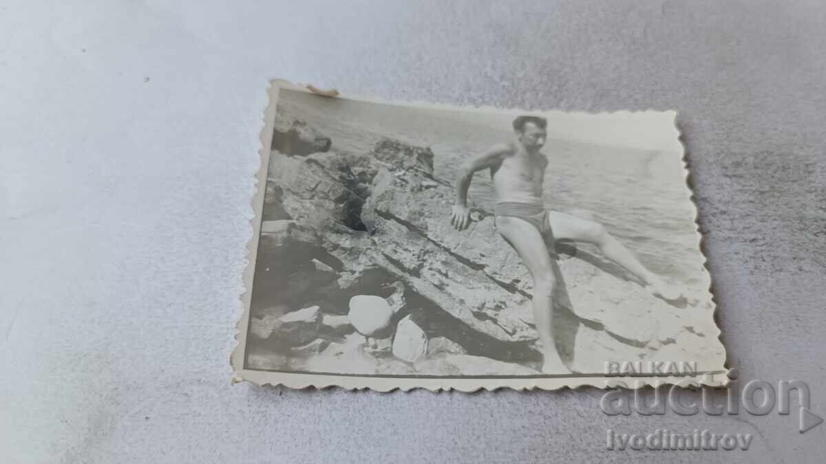 Φωτογραφία Άνθρωπος σε έναν απότομο βράχο πάνω από τη θάλασσα