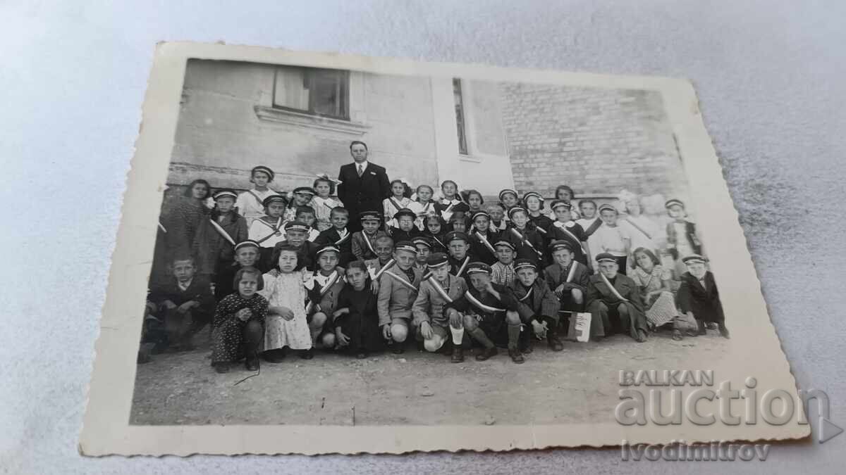 Foto Elevii cu profesorul lor în curtea școlii