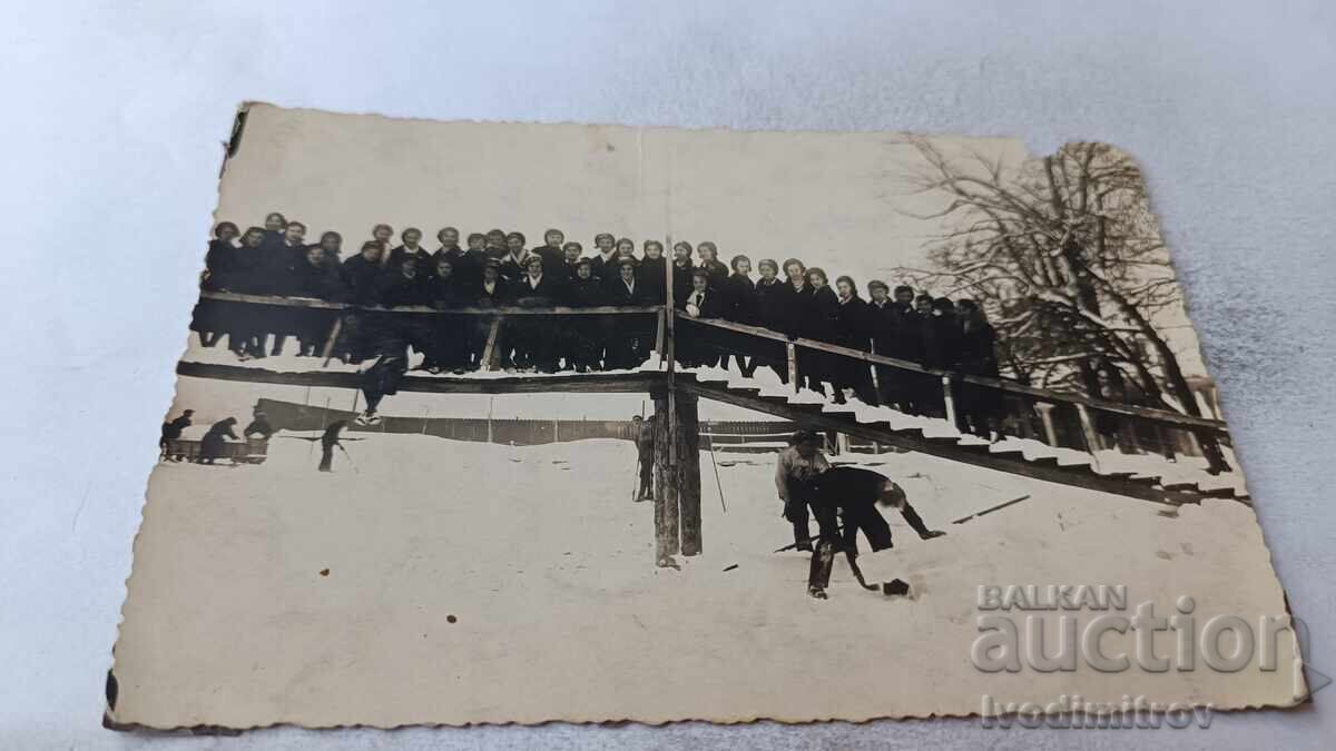 Fotografie cu eleve pe un pod de lemn iarna