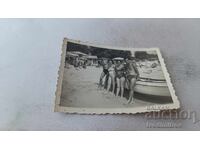 Fotografie Bărbați și femei lângă barcă de agrement pe plajă
