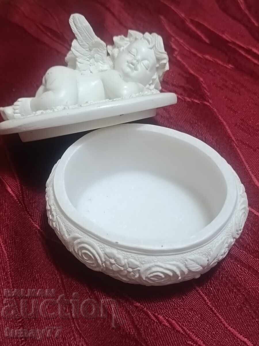 Auction  Jewelry seated angel with a small bouquet in raised right hand