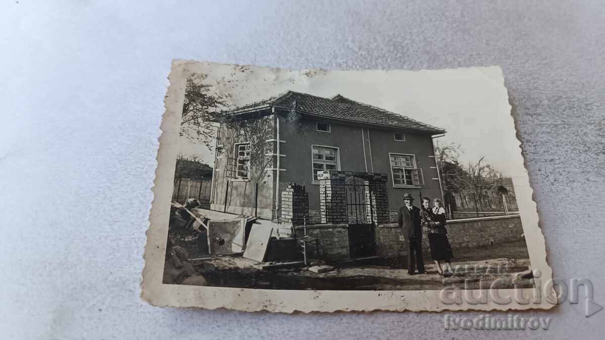 Φωτογραφία Άνδρας γυναίκα και μικρό κοριτσάκι μπροστά από μονοκατοικία Φωτογραφία Άνδρας γυναίκα και μικρό κοριτσάκι μπροστά από μονοκατοικία