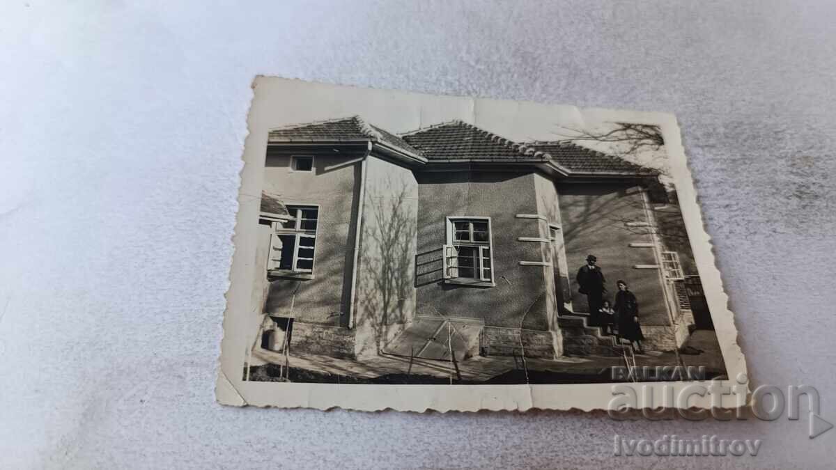 Photo of a man, woman, and little girl in front of a single-family house Photo of a man, woman, and little girl in front of a single-family house