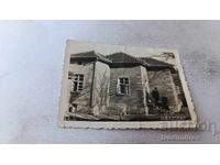 Photo of a man, woman, and little girl in front of a single-family house