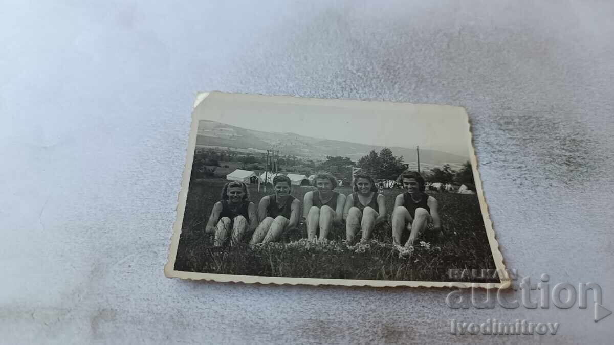 Fotografie cu cinci fete tinere în costume de baie retro, stând pe iarbă