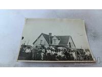 Φωτογραφία Άνδρες και γυναίκες μπροστά από μονοκατοικία