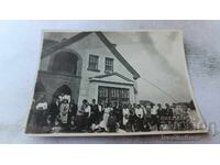 Φωτογραφία Άνδρες και γυναίκες μπροστά από μονοκατοικία