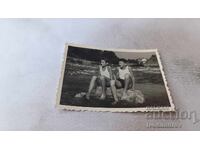 Φωτογραφία Δύο αγόρια κάθονται σε βράχο στη θάλασσα