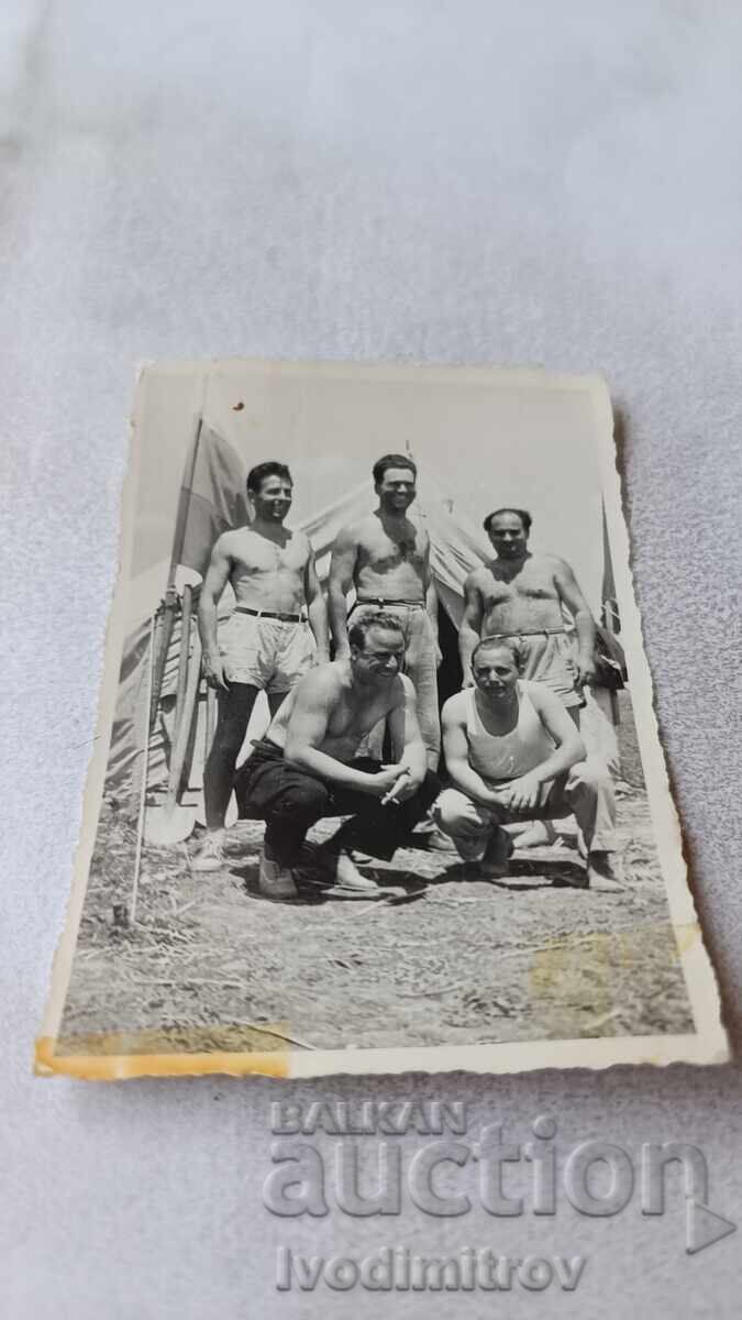 Φωτογραφία Πέντε άνδρες με κοντά παντελόνια μπροστά από σκηνές