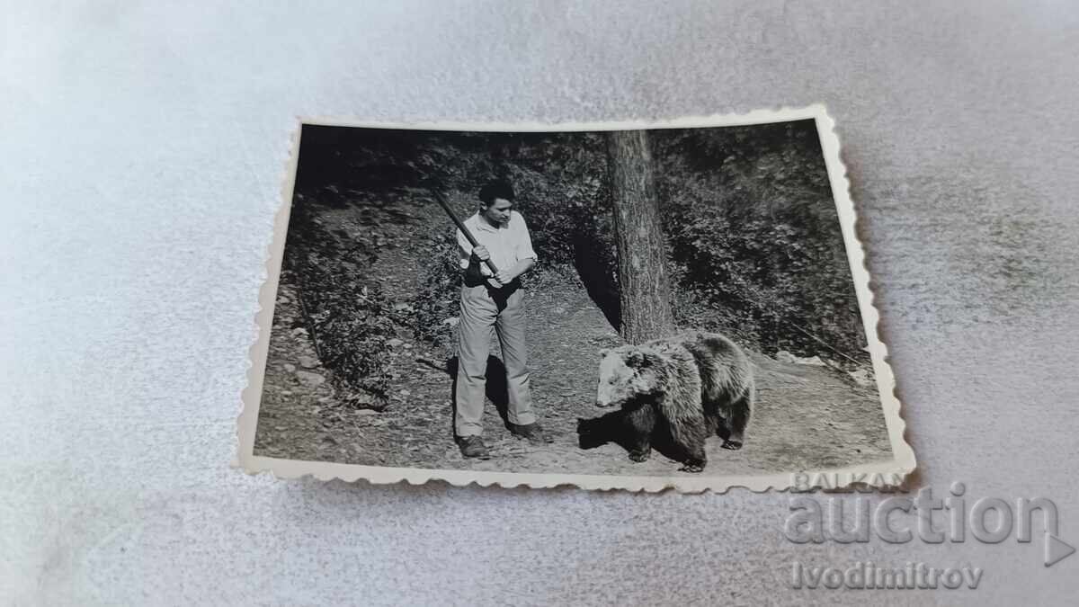 Fotografie Bărbat cu băț și urs