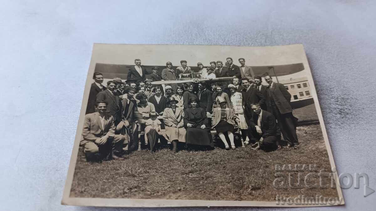 Photo of Men and Women in Front of a Propeller Plane Photo of Men and Women in Front of a Propeller Plane