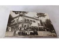 Fotografie Bărbați, femei și copii în fața unei stații de odihnă