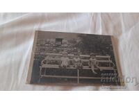 Φωτογραφία Τρία μικρά κοριτσάκια κάθονται σε ξύλινο παγκάκι