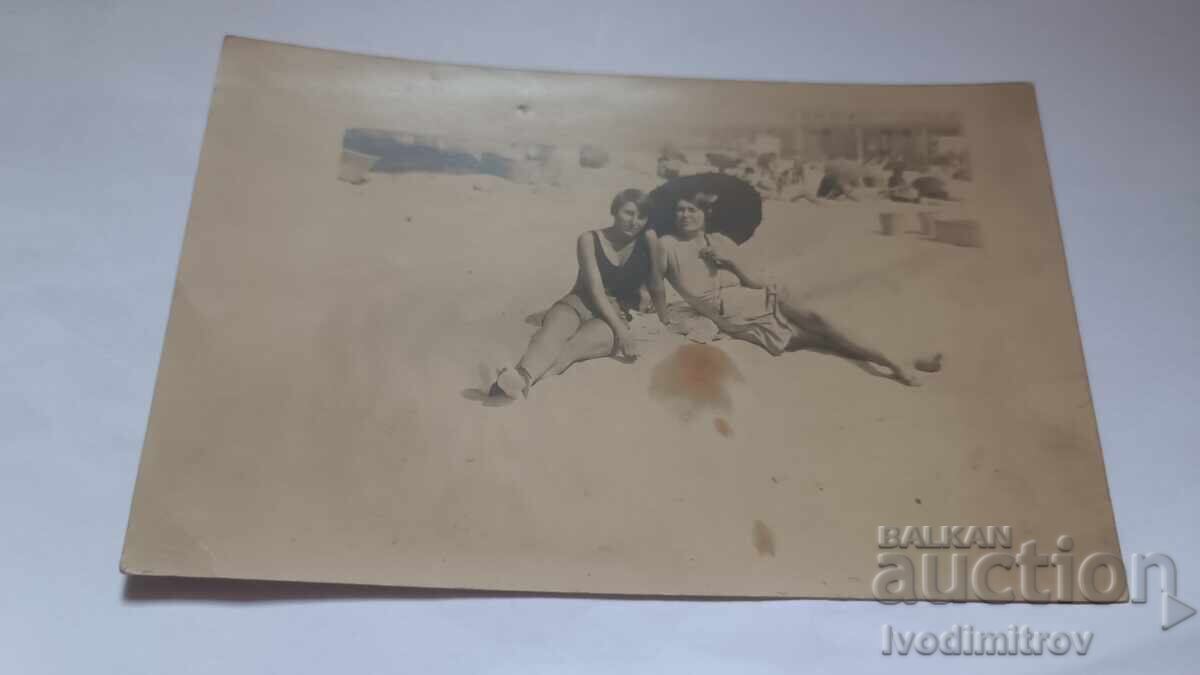 Φωτογραφία Δύο νεαρών κοριτσιών με ομπρέλα στην παραλία