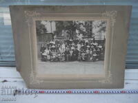 Φωτογραφία παλαιού χαρτονιού με παιδιά μπροστά στην περίφραξη του σχολείου