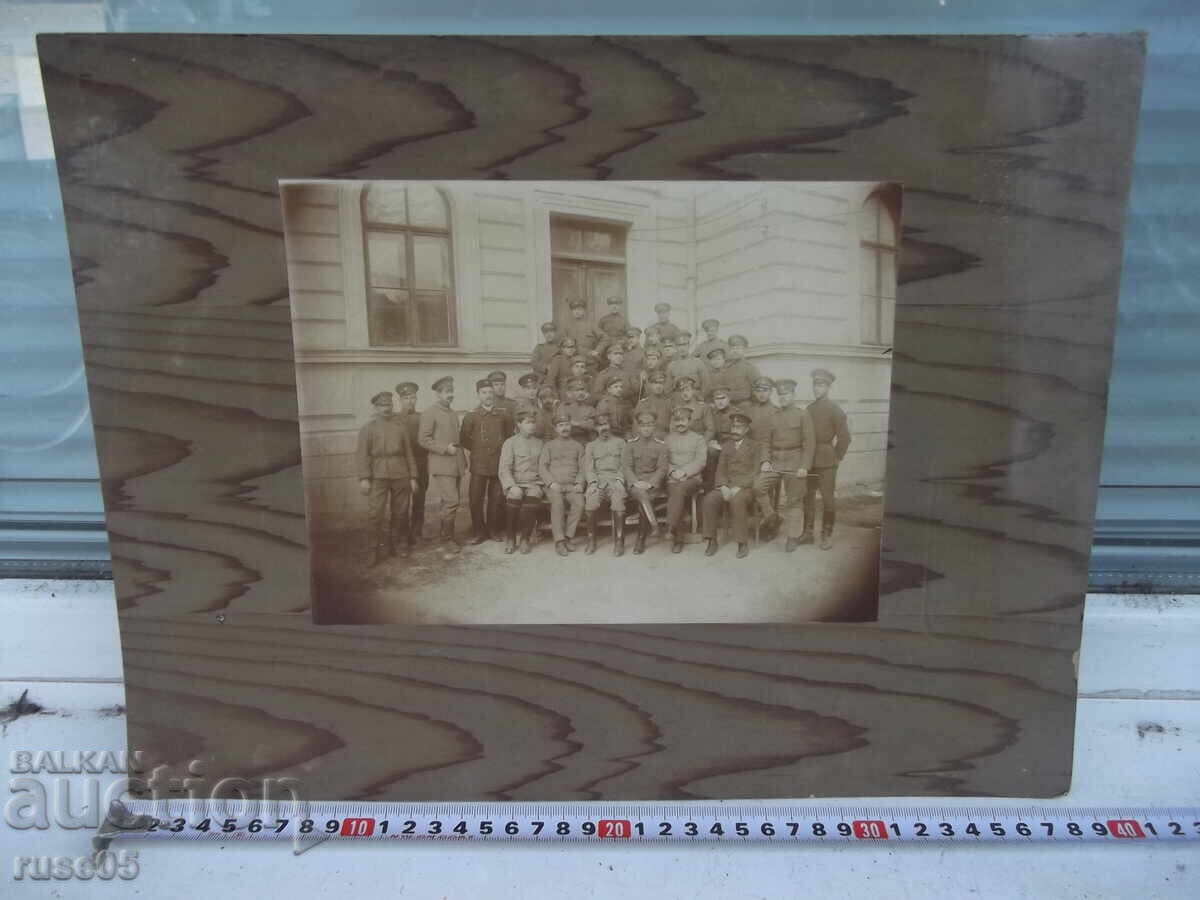 Fotografie veche pe carton cu bărbați în uniforme în fața intrării unei clădiri