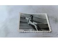 Fotografie: Tânăra fată șezând pe o barcă pe plajă