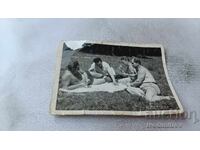 Fotografie cu bărbați jucând cărți pe iarbă