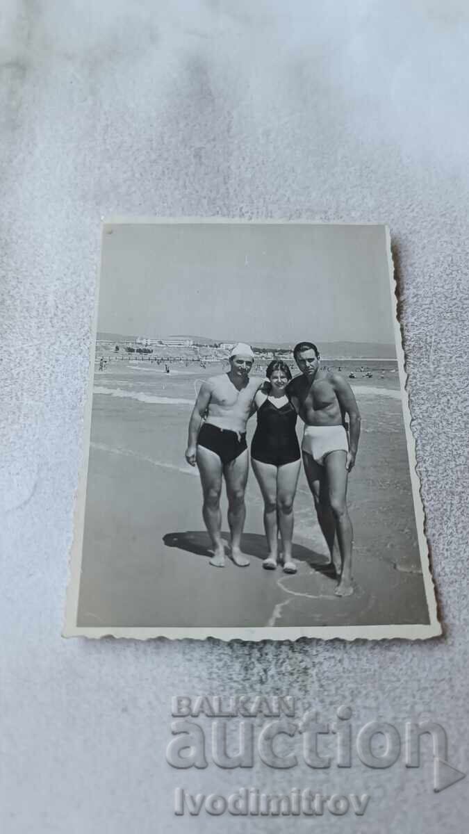 Fotografie Doi tineri și o fată pe malul mării Fotografie Doi tineri și o fată pe malul mării