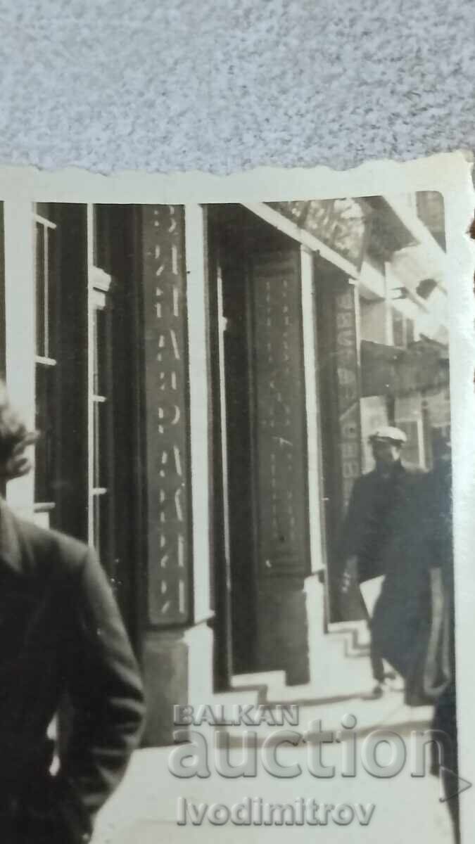 Photo Sofia Young woman in front of a Wine and Rakia shop with price 2.45 BGN | € 1.25