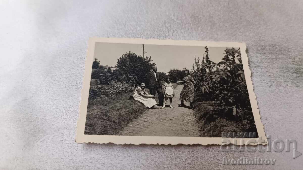 Photograph of a man, two women, and a girl on a path in the park, 1937
