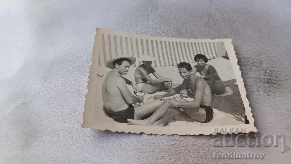 Снимка Мъже и жени играещи карти на плажа